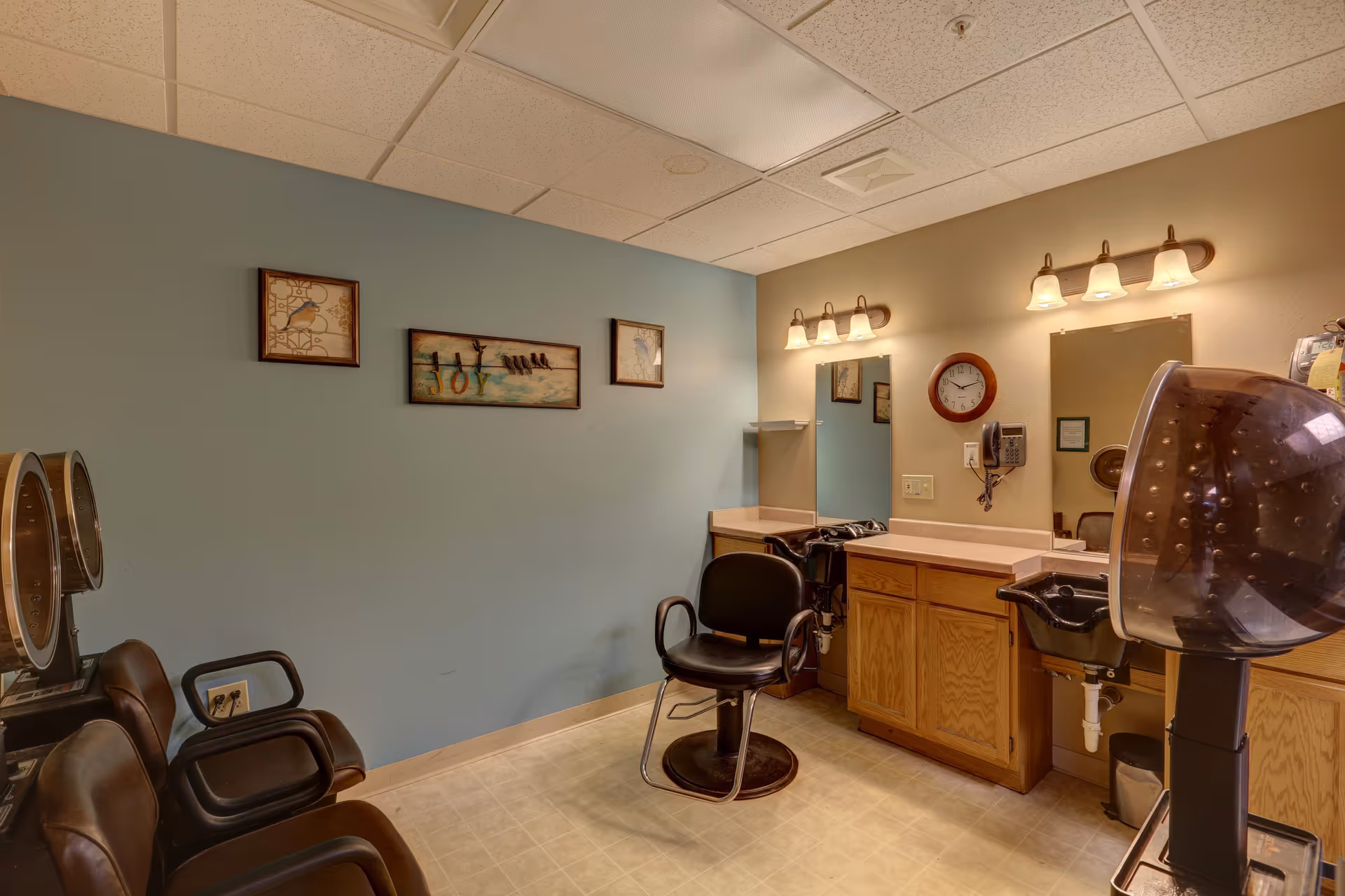 Interior salon/barber room with styling chairs, mirrors, sinks, and wall decor.