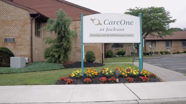CareOne at Jackson sign in front of brick building with flowers.