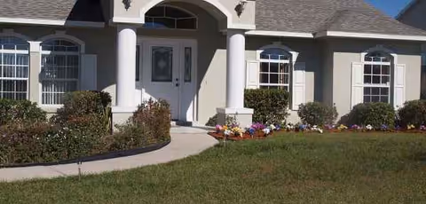 Exterior view of Ellison Adult Family Care Home entrance with columns and landscaping.