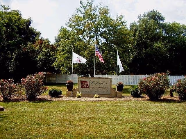 Entrance sign reading 'Effingham Healthcare & Senior Living' on a landscaped lawn with three flags and trees behind.