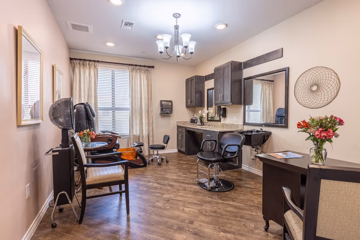 Interior salon room with styling chairs, a hooded dryer, a hair-washing sink, cabinets, and a window with curtains.