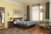 A cozy bedroom with a double bed covered in a plaid blanket, two nightstands with lamps, a framed artwork on the yellow wall, a patterned rug on the wooden floor, a window with sheer curtains, and a cushioned armchair with pillows.