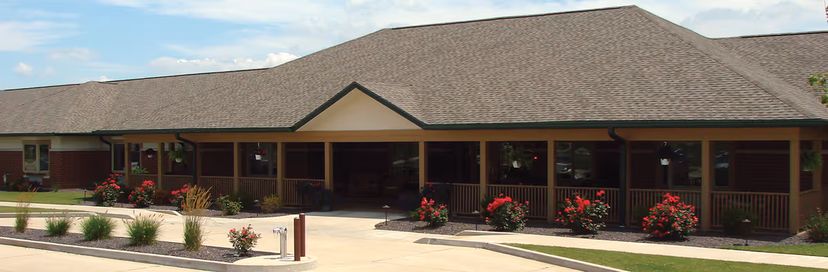 Single-story senior living facility with a covered front entrance and landscaped walkway.