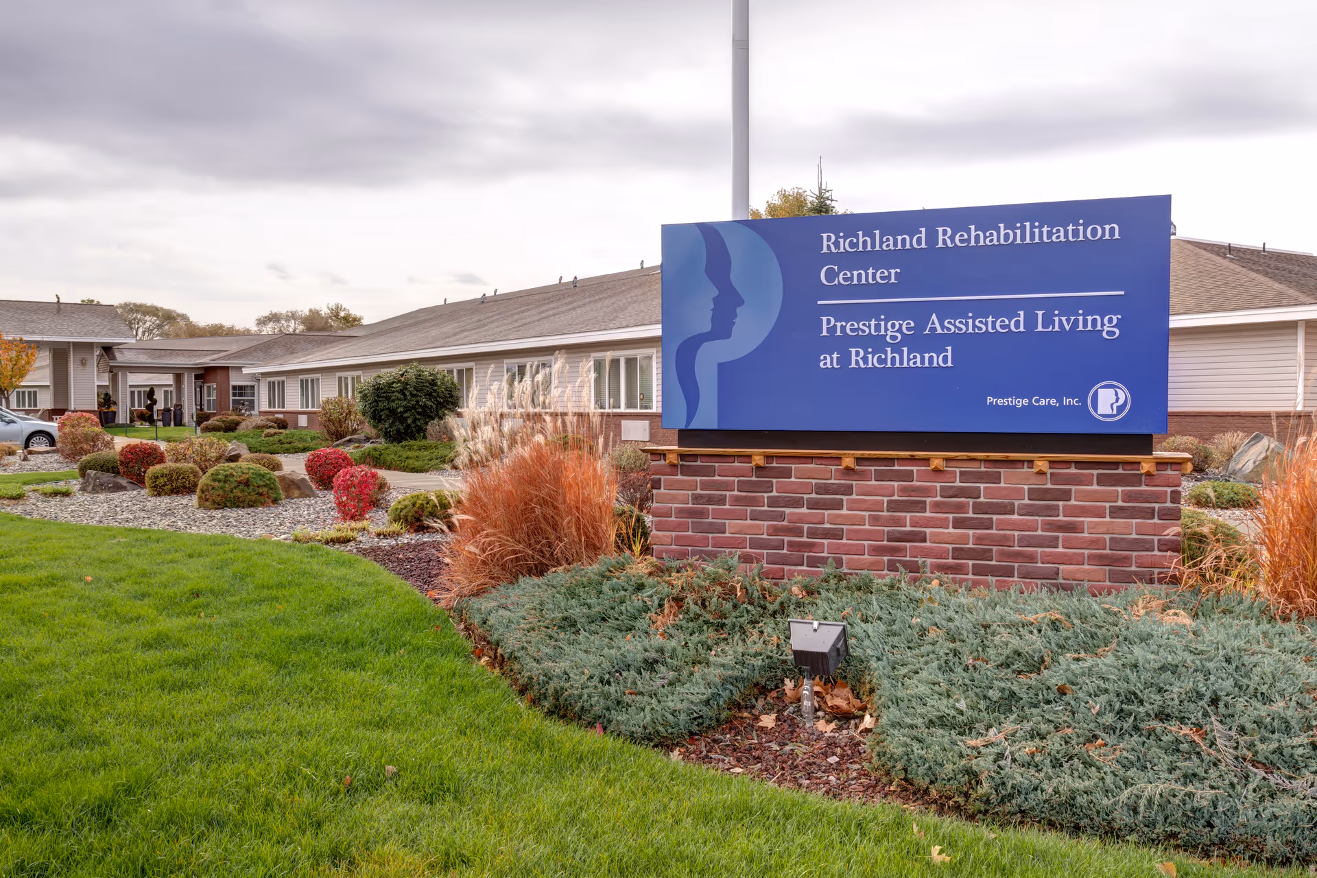 Exterior view of Richland Rehabilitation Center with landscaped gardens and signage.
