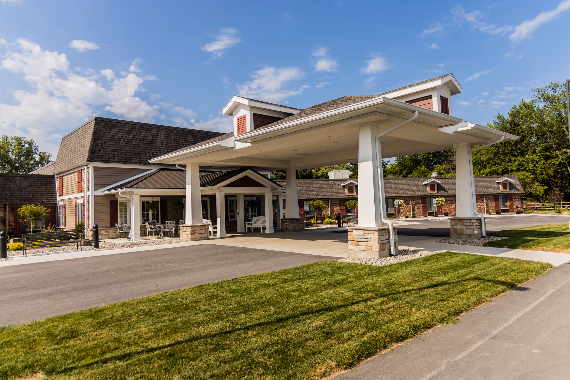 Front entrance of Bowling Green Manor with a covered porte-cochere, driveway, and landscaped lawn.