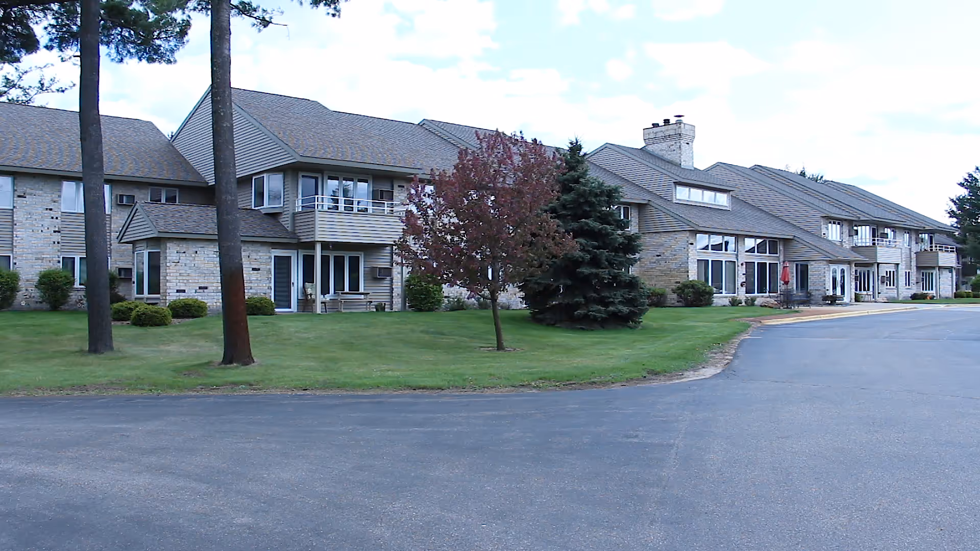 Exterior view of River Run Assisted Living building with green lawn and trees