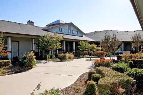 Exterior view of a single-story senior living facility with landscaped grounds