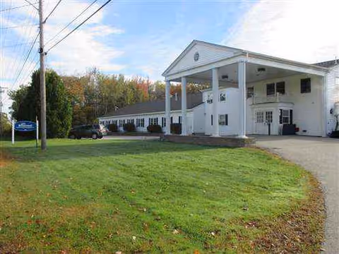 White Brentwood Rehab and Nursing Center building with a covered entrance and green lawn