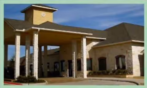 Exterior view of a senior living facility entrance with a covered drop-off.