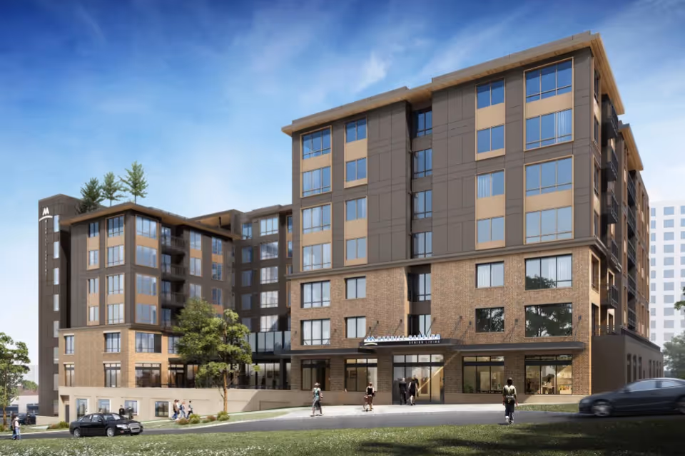Exterior view of a multi-story brick-and-glass senior living building with a landscaped entrance and people nearby.
