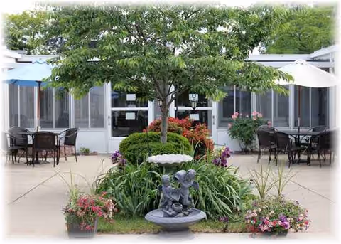 Outdoor courtyard at Medilodge of Taylor with seating, plants, and a central fountain.