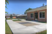 Front exterior of Kingston Rehabilitation and Nursing Center with brick walls and paved walkways.