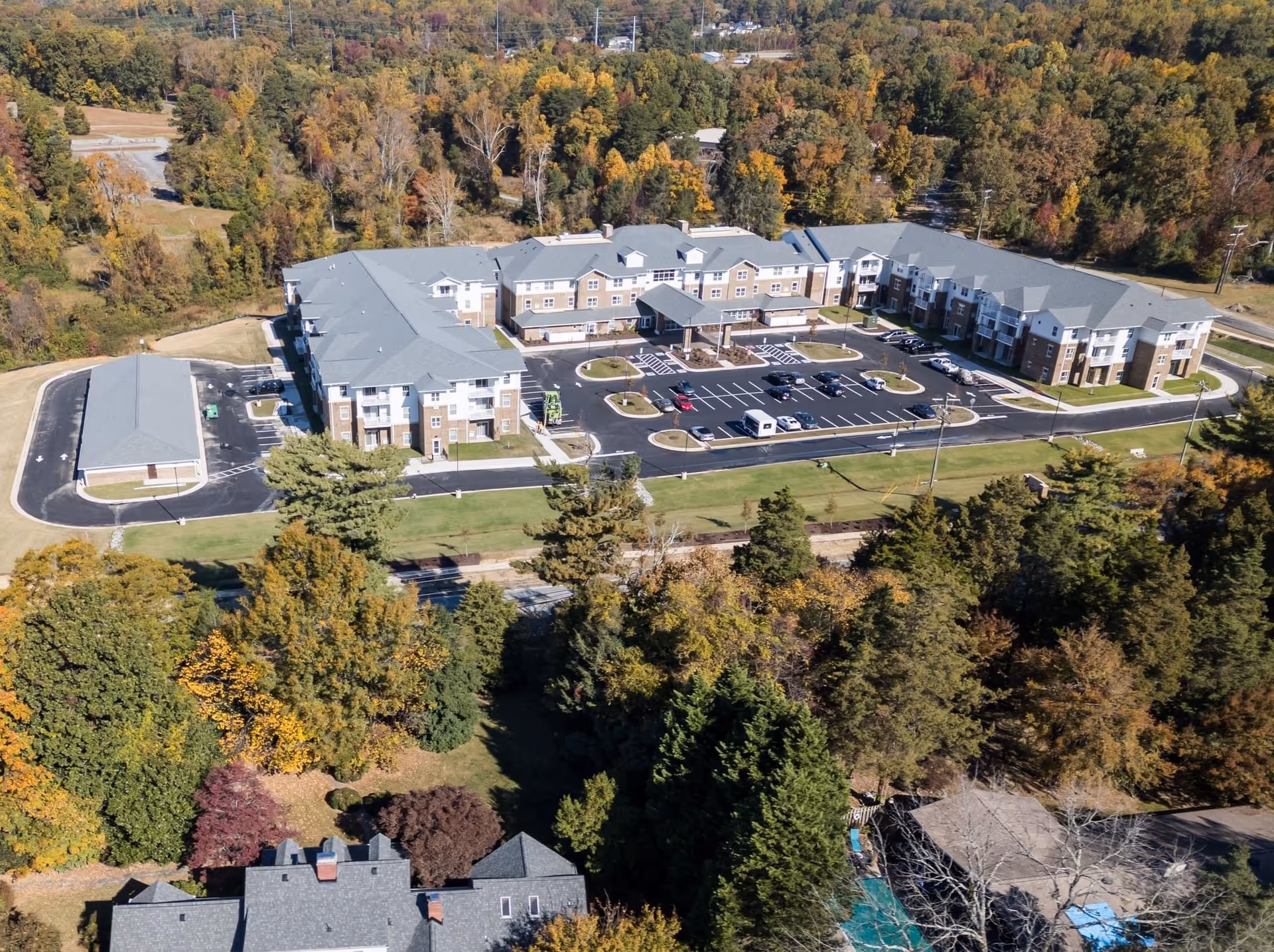 Aerial view of Carolina Pines senior living campus with parking and autumn trees.