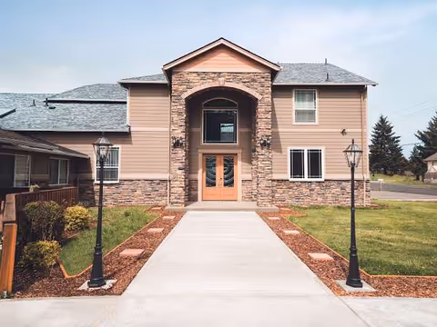 Front view of Michelle Adult Care Home exterior with stone archway and walkway.
