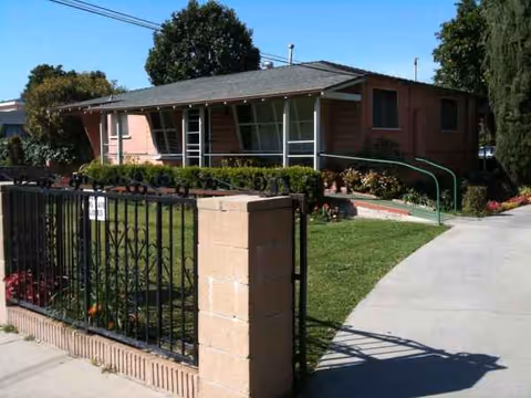 Single-story brick facility with gated front walkway, ramp, and manicured landscaping.