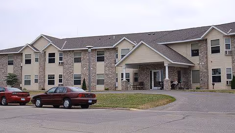 Exterior view of Meadows of Mabel senior living facility with parked cars.
