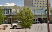 Front exterior of a two-story building with a parking lot in front.