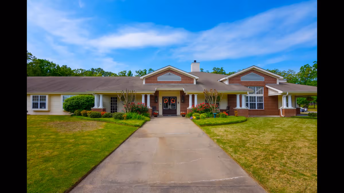 Front view of Willow Grove of Maumelle facility with brick facade, walkway, and landscaped lawn.