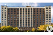 Front view of a tall brick Hillside Manor Rehabilitation senior living building with trees.