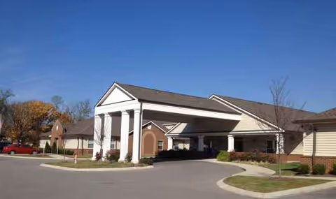 Grace Manor Assisted Living exterior featuring a covered entrance and curved driveway.