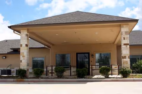 Front entrance of Shady Shores of Hemphill with covered porch and shrubs.