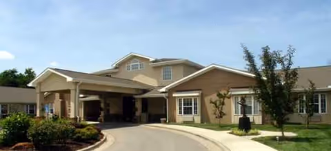 Exterior view of Brookdale Rosehill facility with driveway and covered entrance