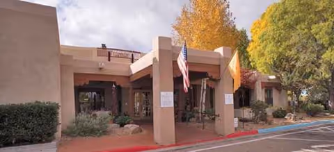 Front entrance of Brookdale Santa Fe senior living facility with a covered entry and American flag.