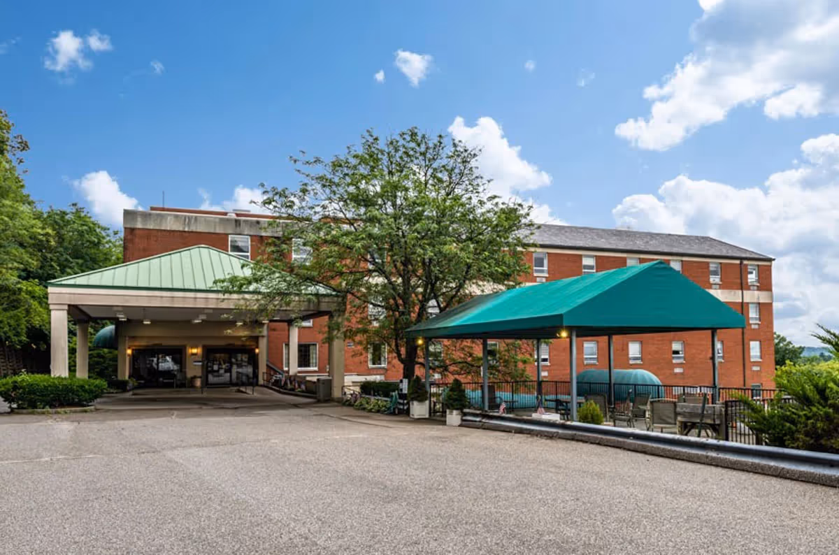 Exterior view of The Mariemont Care Center featuring a green awning and surrounding trees.