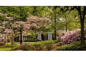 Exterior view of Royal Oaks senior living facility with trees and shrubs by the entrance
