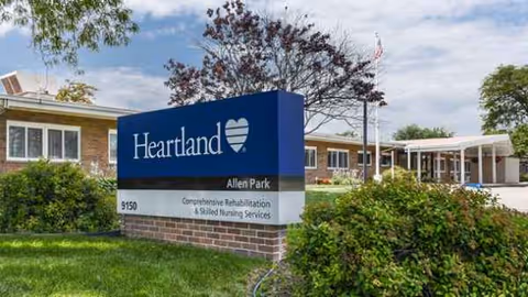 Exterior view of a senior living facility sign beside a brick building.