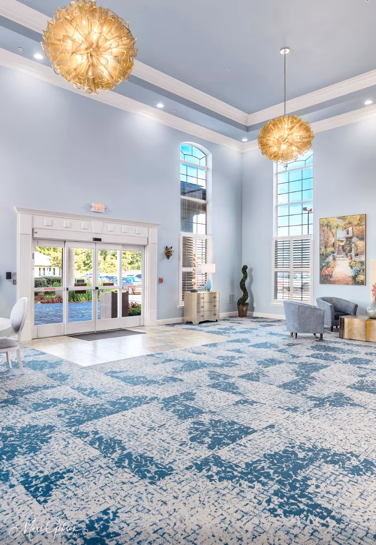 A spacious lobby area in a senior living facility featuring decorative lighting and furniture.