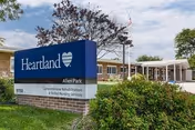 Exterior of a building with a blue Heartland sign and a white, covered entrance.