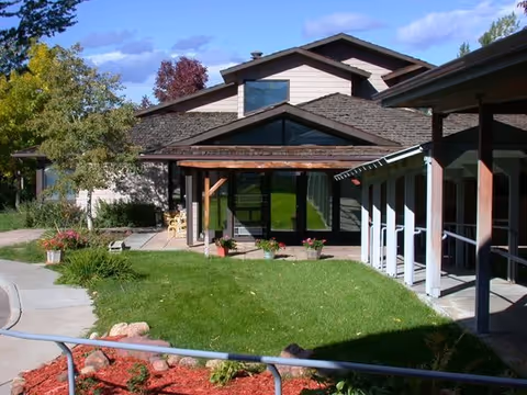 Front exterior of The Mary Sandoe House with green lawn and covered entry.