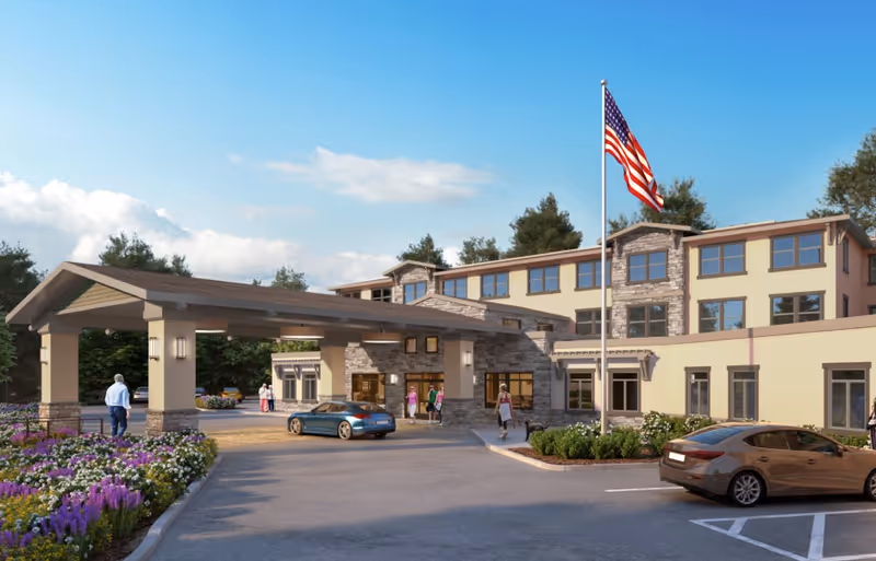 Senior living facility entrance with porte-cochère, flag, and parked cars outside The Grove at Los Gatos.