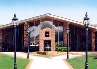 Front view of Bellevue Health and Rehabilitation Center with brick entry, lawn, and lamps.