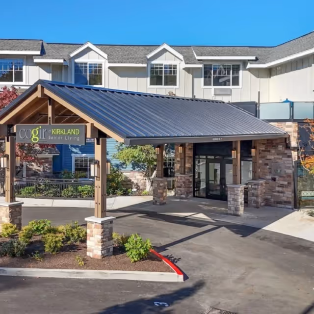 Exterior view of Cogir of Kirkland senior living with a covered entrance and stone pillars.
