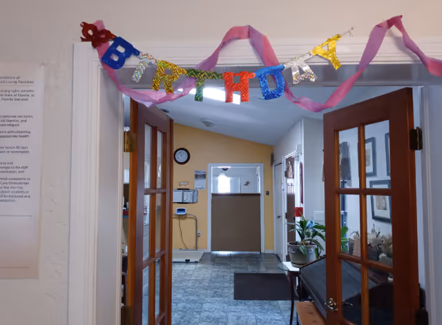 Doorway opens to a decorated interior hallway with a birthday banner.