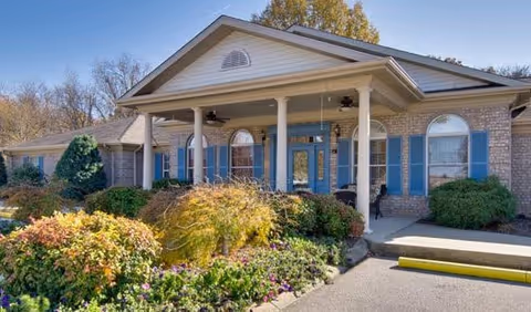 Front exterior of Greenbrier Meadows senior living facility with brick facade and landscaped entry.
