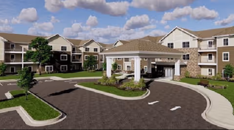 Exterior view of a senior living facility with a circular driveway and porte-cochere.