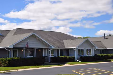 Front exterior view of Bay Road Place senior living facility with shrubs.