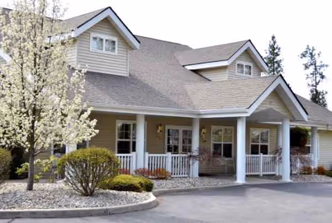 Front view of a beige senior living facility with a covered entrance.