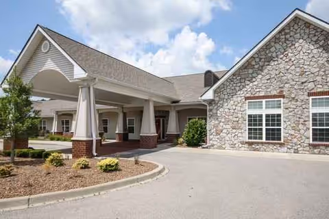 River Crossing senior living facility exterior with stone facade and a covered entrance.