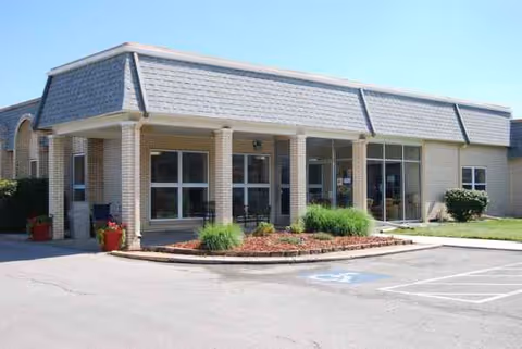 Front exterior view of Meadowbrook South Campus entrance with glass doors and landscaping.