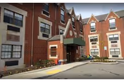 Brick senior living facility exterior with entrance canopy and surrounding driveway.
