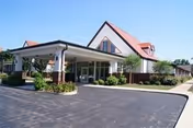 Exterior view of Greenfield Retirement Home with a covered entrance and landscaped driveway.