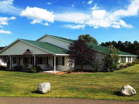 Exterior of a single-story senior living facility with green roof and manicured lawn.