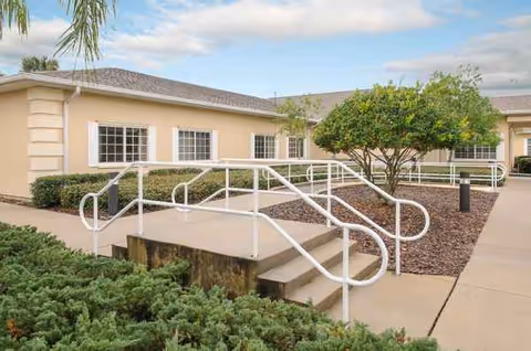 Exterior of Life Care Center of New Port Richey with ramp and landscaped walkway