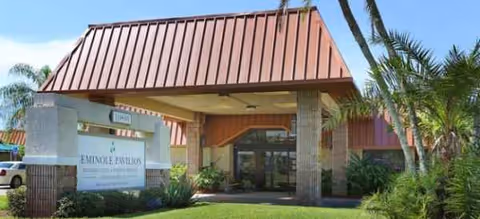 Front entrance of Seminole Pavilion Rehabilitation & Nursing Service with a red roof and palms.