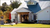 Exterior view of Birch Haven Senior Living Eagles Ridge with outdoor seating on a sunny lawn.