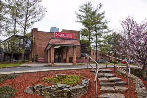 Exterior view of Northern Metropolitan senior living facility with brick entrance and landscaped steps.